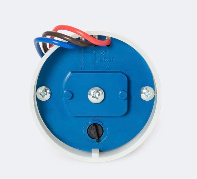 sensor crepuscular con capacidad de encender o apagar automáticamente la luz según la luz ambiental. Es adecuado para uso en exteriores y se monta en superficie, ya sea una pared o en el mismo poste de la luminaria.
Este Sensor Crepuscular Superficie 10A IP44 puede soportar una potencia LED de 2400W con una corriente nominal máxima de 10A. Tiene una clasificación IP44, lo que lo hace resistente a la entrada de polvo y agua. Además, funciona con una tension de 220V-240V y una frecuencia de 50/60Hz. 